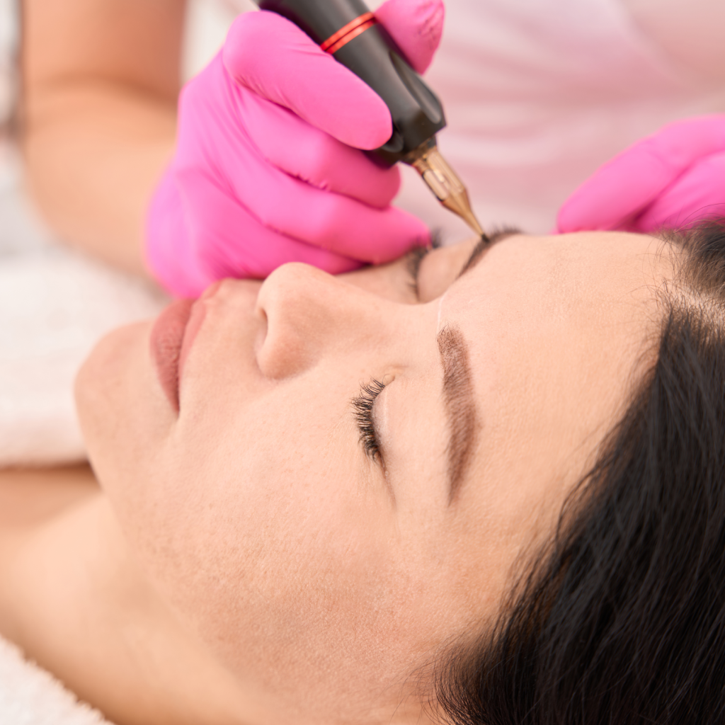 Permanent makeup near me – skilled artist performing eyebrow tattoo procedure with precision using professional tools.