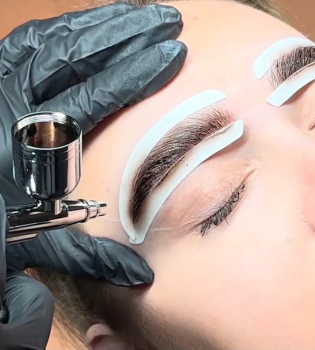 Airbrush eyebrow tattoo procedure as part of permanent makeup near me services for precise and natural-looking brows.